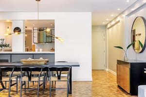 Foto de un comedor con mesa de madera teñida de color oscuro y llamativa lámpara de Paul French Gallery.
