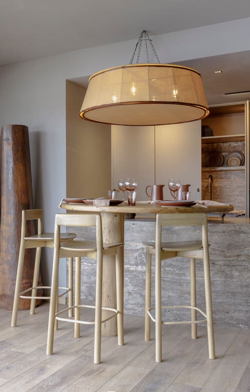Foto de una cocina integrada al comedor de un depto con mesa y sillas altas de madera.