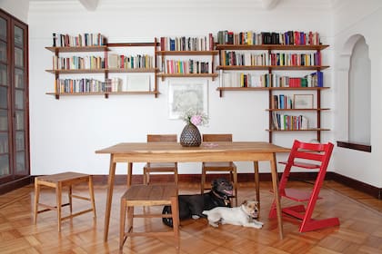 Mesa y sillas (La base). La obra de arte es de Mariana Sissia. La biblioteca (La base) es la protagonista del comedor. Encastrable y colgante, se adaptó a cada casa en la que vivieron.
