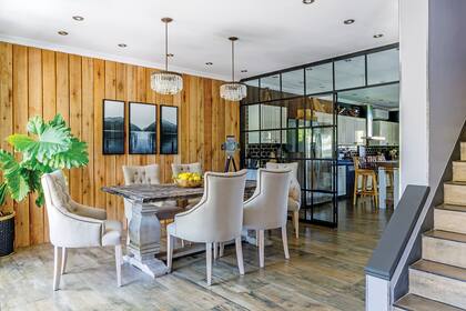 Sillas y mesa (Gloria Atelier Deco). Lámparas de techo (HSD Ilum). Tríptico (Henri’s Gallery). Revestimiento de eucalipto (Easy). Lámpara de pie (Puerto de Frutos).