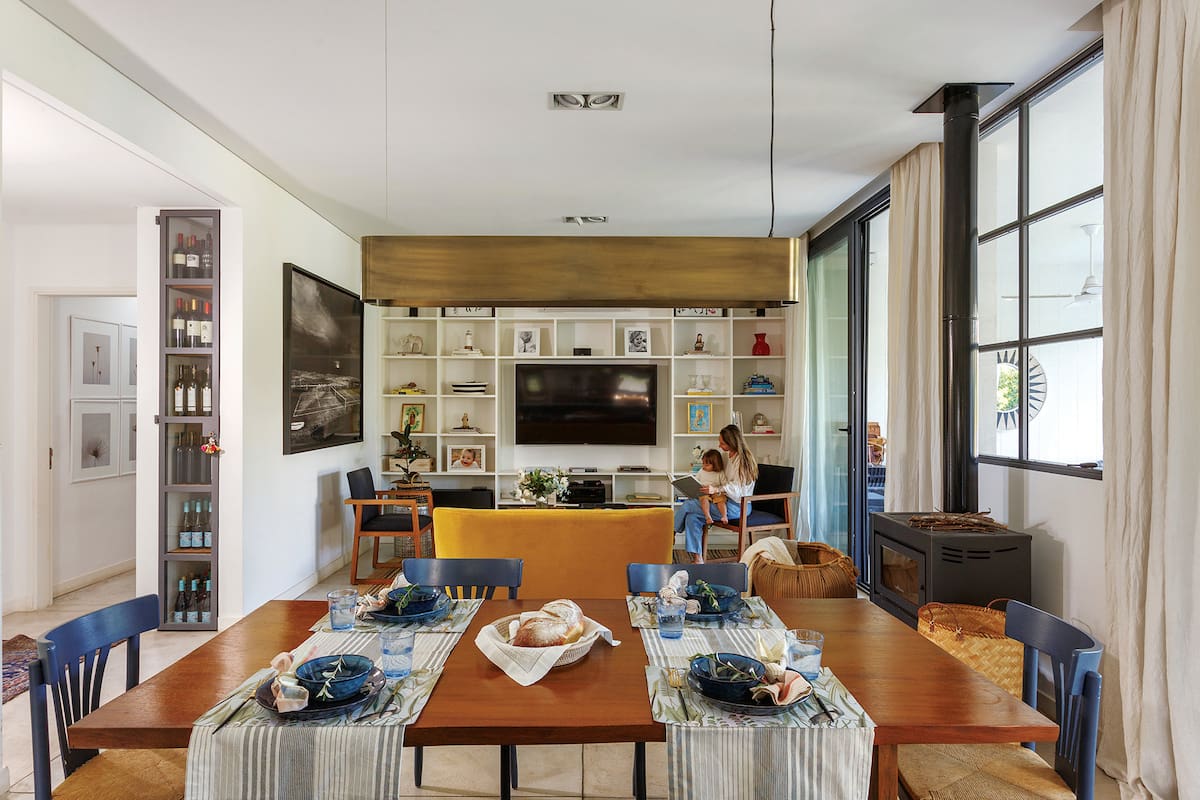 Foto de un comedor integrado al living con mesa de timbó, caminos, individuales y servilletas.