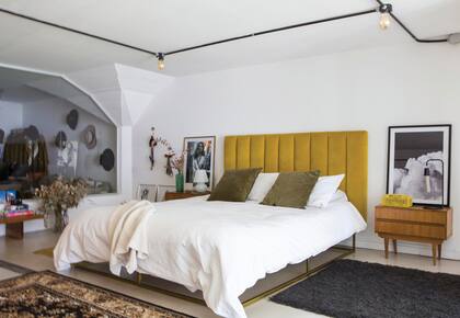 La cama se mandó a hacer con base cobreada a tono con el género del respaldo (LB Géneros). Almohadones (Apatheia), funda de edredón (Philomena Home) y manta tejida (Arredo).