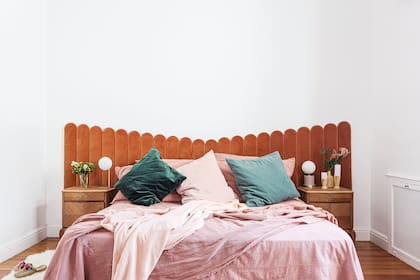 Cama con respaldo ‘Gaia’ (realizado por Calé junto a Cirilo Mobiliario), revestido en pana de algodón color almendra (De Levie), mesas de noche vintage que fueron restauradas, lámparas diferentes de cada lado (I Wish Deco). Manta y almohadones (Géneros Carolina Biercamp).