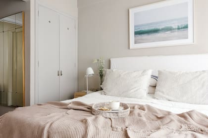 Cama con respaldo ‘Lola Basic’, almohadones ‘Marinero’, manta ‘Throw Waffle’ con flecos visón, cuadro ‘Montezuma 1’, mesas de noche ‘Madrid’ (todo de Apatheia). Lámpara de mesa (Via Luce Iluminación).