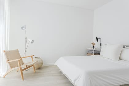 Foto de un dormitorio con mesas de luz de hierro y ropa de cama blanca.