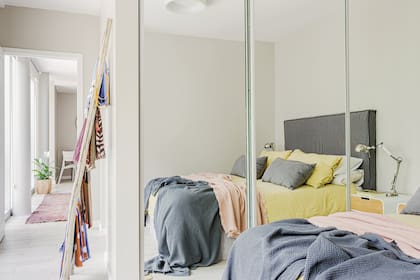 Respaldo (Filipponi Deco). Mantas gris y rosa (Sol Palou). Lámparas, mesas de luz, funda de edredón color maíz y almohadones (todo de Ikea).