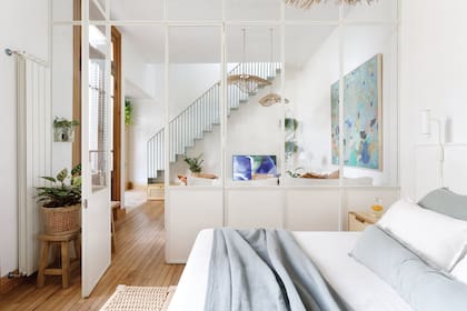 Mampara de hierro y vidrio (MF Herrería). Almohadones y manta (Bonhomía Haus). Sin otra pared donde ubicar un radiador de tamaño suficiente para climatizar el cuarto, buscaron hasta dar con este.