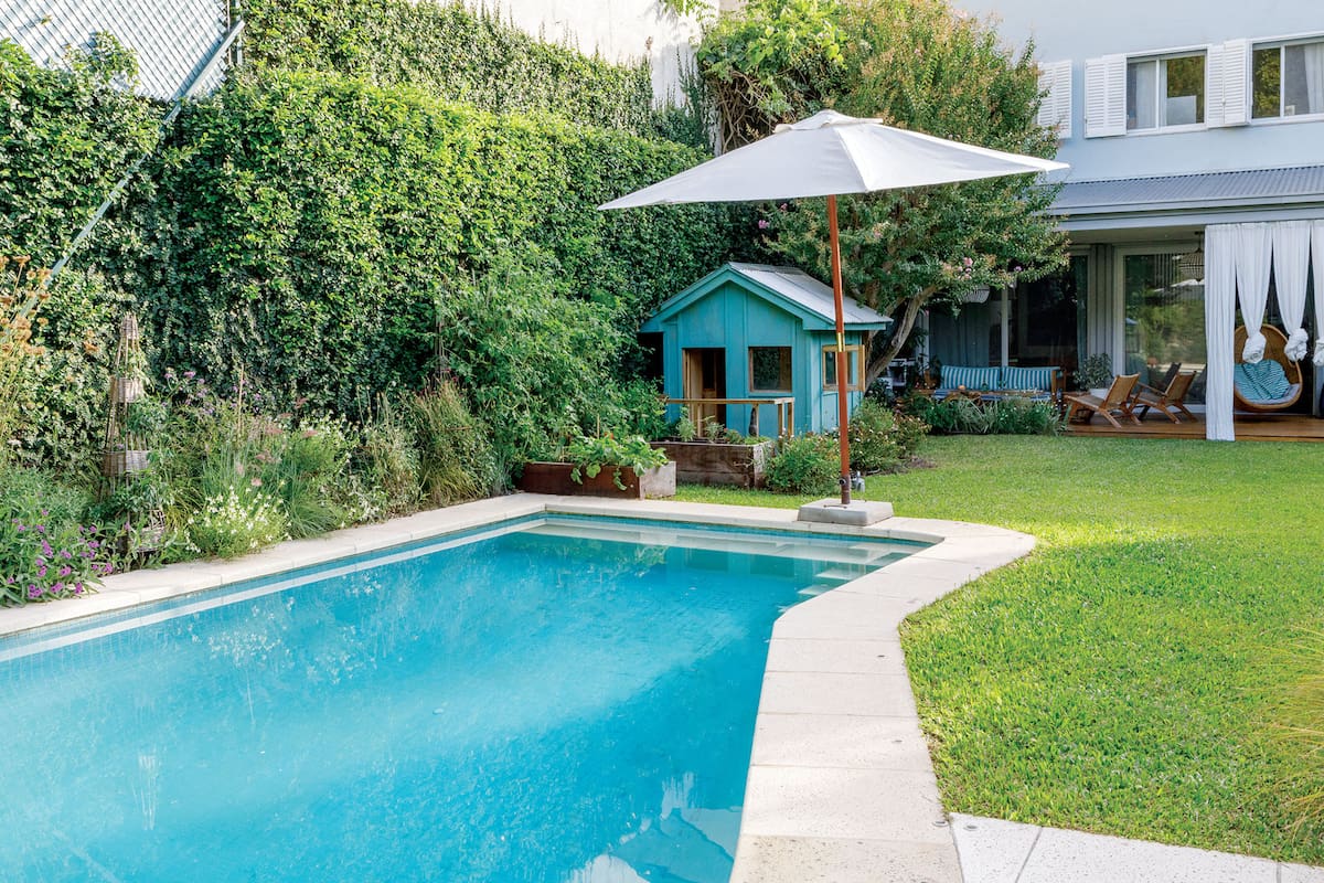 Foto de un jardín con pileta, pasto y casita de madera.