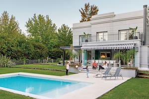 Foto de un jardín con pileta, toldo y escalones con alzada de cerámicos.