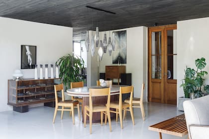 La mesa fue un préstamo de una amiga de Marina. “Que sea ovalada, además de que resulta algo original, te corre de la idea formal de una mesa con lugares asignados”. Sillas (La Base Studio).