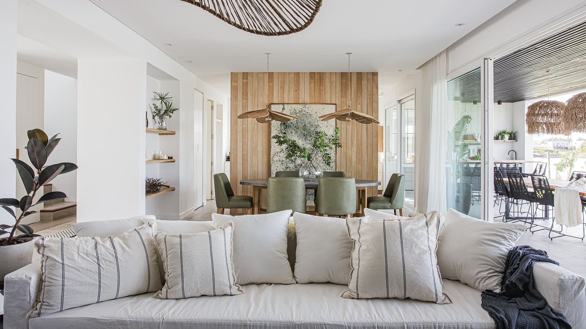 Foto de un living comedor con sillón de tussor, almohadones y lámparas colgantes.