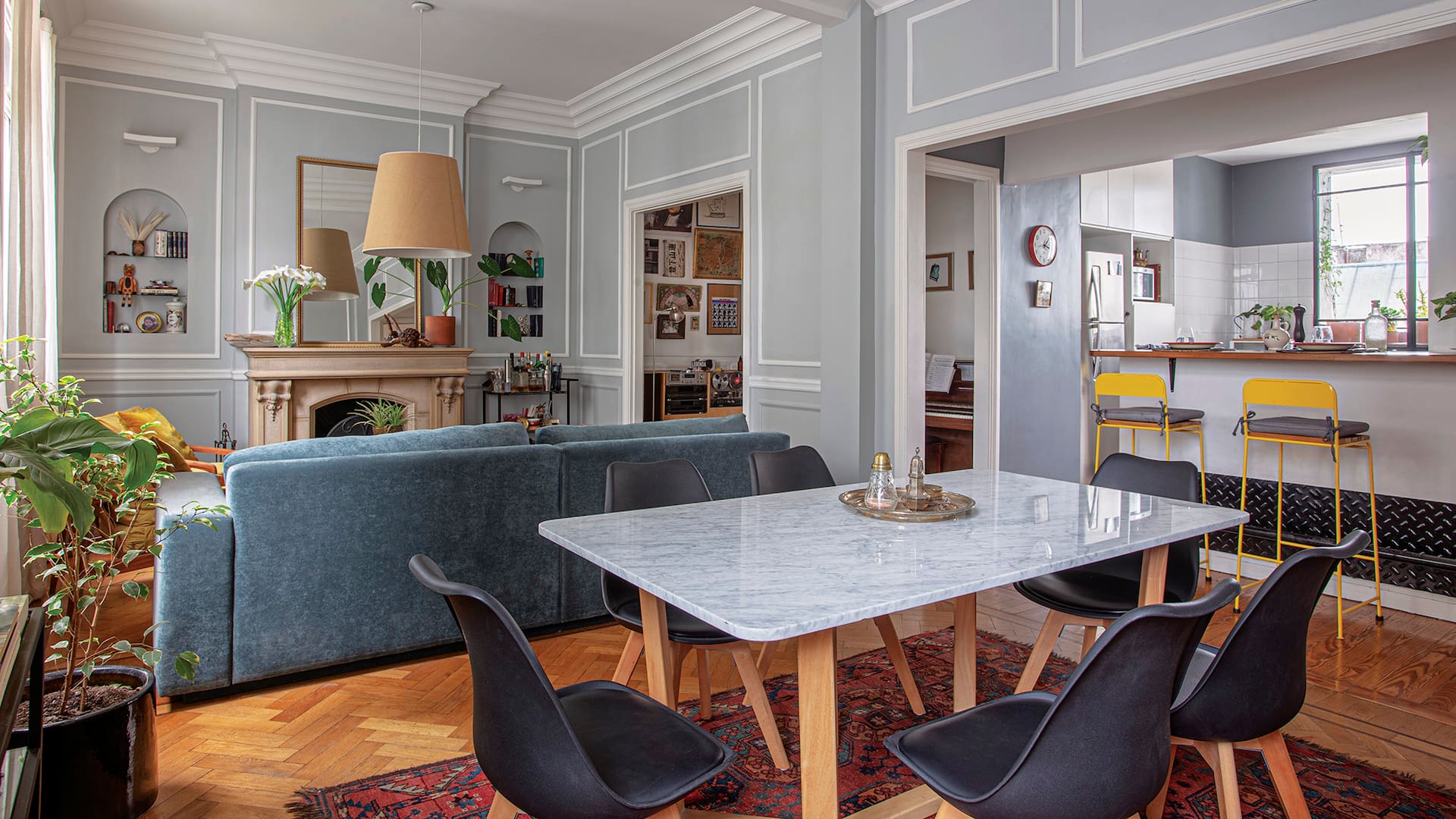 Foto de un living-comedor mesa de comedor hecha a medida en petiribí y mármol de Carrara y sillas ‘Cross Wood’ con patas de madera.