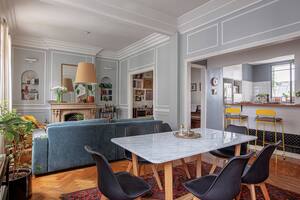 Foto de un living-comedor mesa de comedor hecha a medida en petiribí y mármol de Carrara y sillas ‘Cross Wood’ con patas de madera.