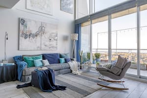 Foto de un living con mesa-banco de madera y sillón gris.