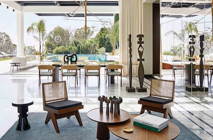 Negro y madera para uno de los espacios de estar y el comedor. Sillas años 50 del arquitecto suizo Pierre Jeanneret (primo de Le Corbusier, con quien colaboró durante años). Mesas de centro (Roche Bobois).