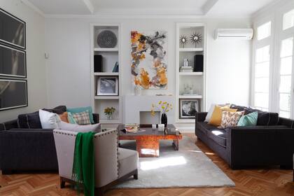 Foto en tríptico blanco y negro de Renee Rumann (Bruggens Gallery). Sillones individuales (Salazar Casa) y enfrentados de pana gris con vivos traídos de la casa anterior. Mesa de raíz de nogal heredada.