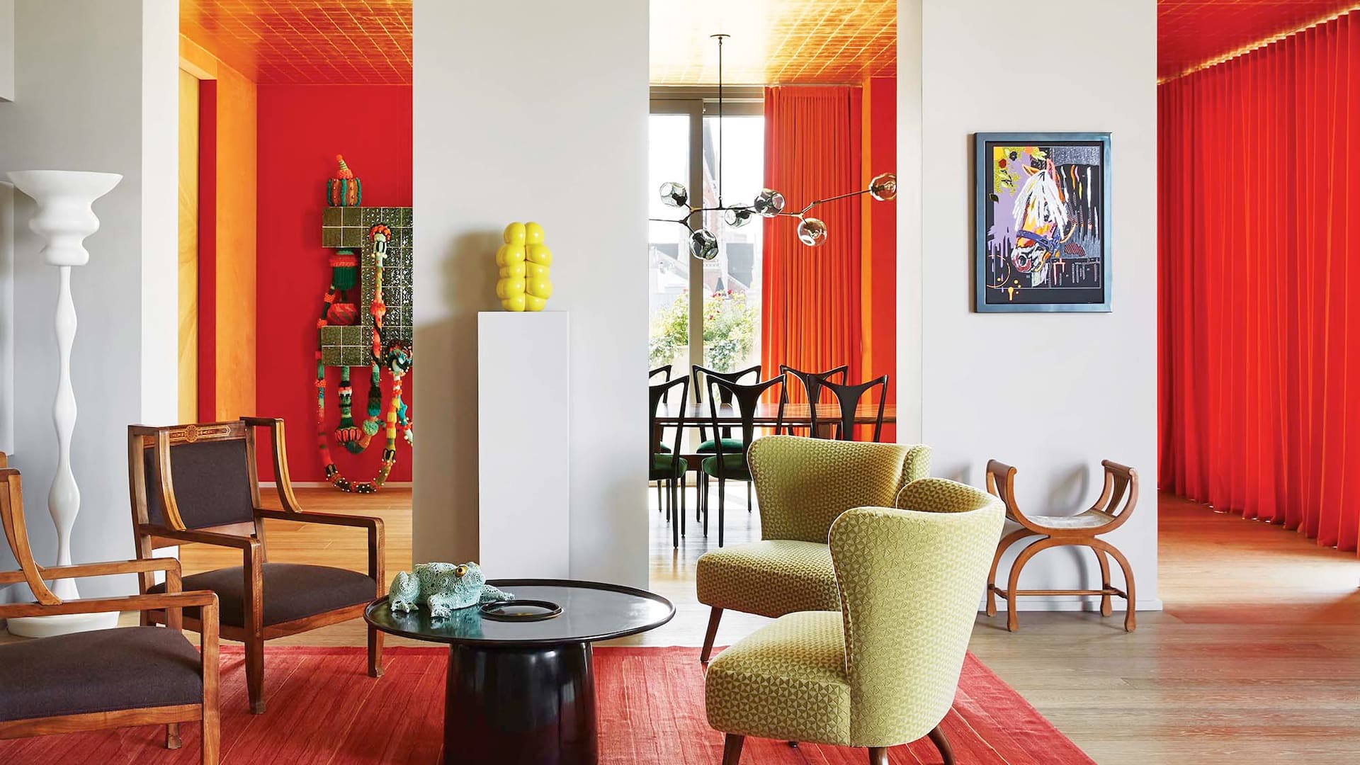 Foto de un living con sillas de madera italianas de 1910; sillones tapizados en terciopelo de Hermès; mesa baja de Eric Schmitt; antiguo armario italiano de caoba; kilim y lámpara de pie del prestigioso estudio de arquitectura suizo Herzog & De Meuron.