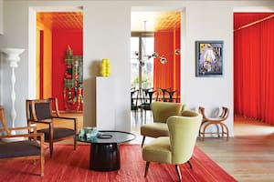 Foto de un living con sillas de madera italianas de 1910; sillones tapizados en terciopelo de Hermès; mesa baja de Eric Schmitt; antiguo armario italiano de caoba; kilim y lámpara de pie del prestigioso estudio de arquitectura suizo Herzog & De Meuron.