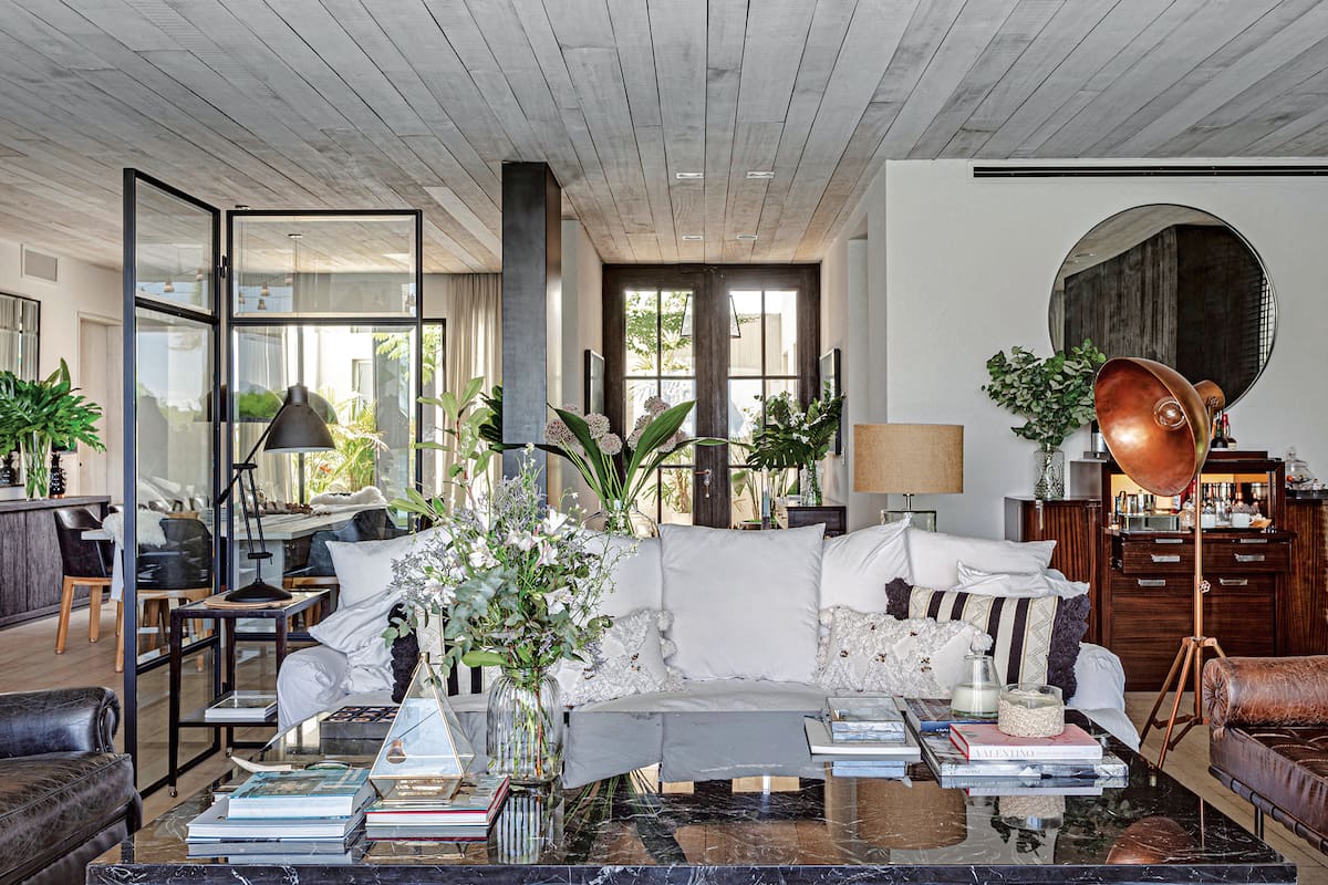Foto de un living con sillón de cuatro cuerpos, mesa baja y biombo.
