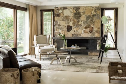 En el living, sillón ‘Marseilles’ de roble platinado y lino, sofá ‘Lincoln’ de cuero, mesas ratonas de altura regulable con patas cromadas y tapa de roble, y lámpara trípode ‘Allen Good’ (todo de Landmark) sobre alfombra patchwork ‘Persia’ (Mihran).