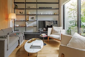 Foto de un living con sillones, biblioteca y mesa ratona con tapa de mármol.