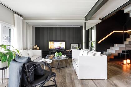 Sillones blancos con ribete negro y cortinas de gasa de algodón off white colgadas con anillos de barral negro (Arq.dco).