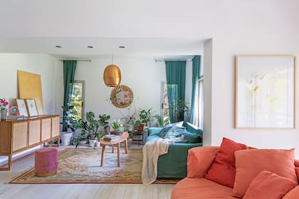 Cortinas de gasa y sofá engamado con funda de lino vintage y asiento de terciopelo (todo, Casa Almacén). Lámpara colgante cobreada (Compañía Nativa) y mesa ratona (Sur del Cruz).