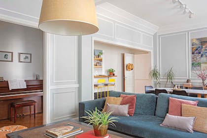 Sofá de pana (Pola Home), lámpara colgante de luz difusa con pantalla de rafia (Iluminación Agüero). Los tableros y boiseries de madera dura se reciclaron cuidadosamente durante la obra.
