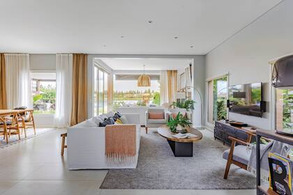 Alrededor de la TV, sillón (Bo-Tikken), almohadones (Woodmarket), manta (Zara Home), alfombra (Ikea), mesa de petiribí y hierro (Q Furniture) y bandeja de mármol ovalada (Quinto Home).