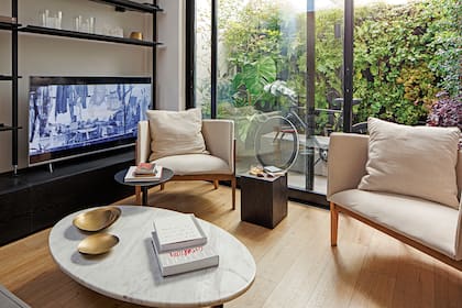 El living convive con un gran patio recubierto con jardines verticales y especies exóticas.