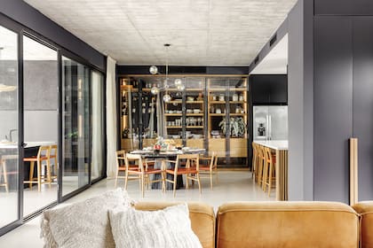 Los módulos del mueble que hilvana la cocina y el comedor, funcionan como bodega-bar, vajillero y despensa.