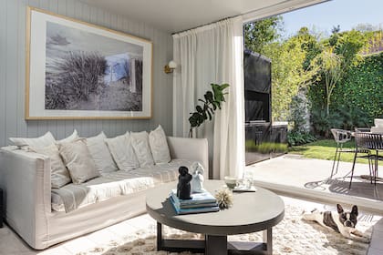 Cortinas de lino (Kotton Linos) motorizadas (Somfy Argentina), sillón, almohadones, mesa ‘Rigby’, alfombra de algodón y cuadro (todo de Salazar Casa).