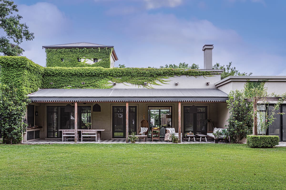 Foto de una casa con galería y jardín.