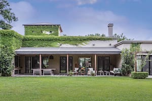 Foto de una casa con galería y jardín.
