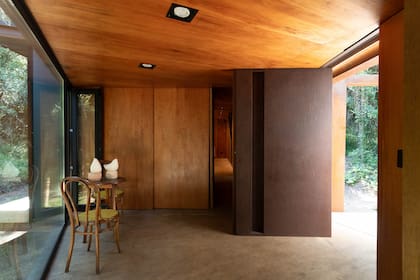La puerta, opaca y sin ninguna ventana, se abre a un hall de recepción o a un cuadro bucólico -como se lo prefiera ver-. Su techo bajo busca acoger y llevar la vista hacia el exterior