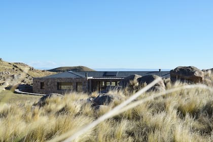 Buscando la integración de arquitectura y paisaje, la casa se construyó dentro de la estructura natural existente, entre las rocas y las lomas del terreno, que la contienen y protegen.