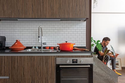 El tajine, clásico de la cocina bereber, y la olla de Le Creuset hablan del gusto de Sebastián por la cocina. Azulejos ‘Brick’ de 5x5 (Piú). Muebles con frente enchapado ‘Zebrano’. Grifería (Andez). Bacha (Johnson Acero). Mesas de granito con tratamiento ‘Leather’ (Eurostone). Cocina (Kipton).