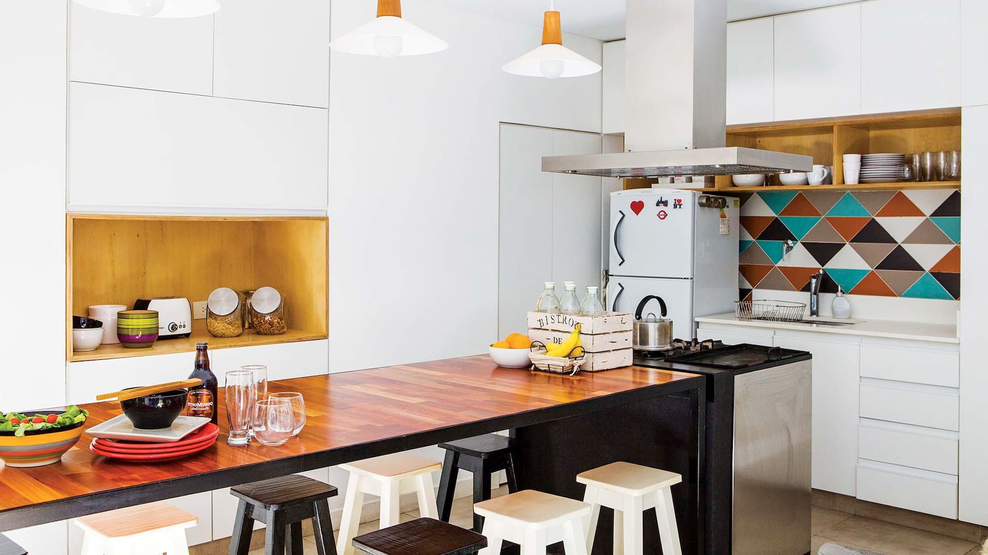 Foto de una cocina con gran isla y lámparas colgantes.