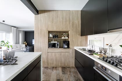 Mesada y alzada de Neolith. Bacha (Johnson Acero) con grifería ‘Newport’ (FV). El extractor ‘Flexa’ (Spar) pasa desapercibido. Bajomesada y alacenas de melamina pintada con laca negra (todo de Arq.dco).