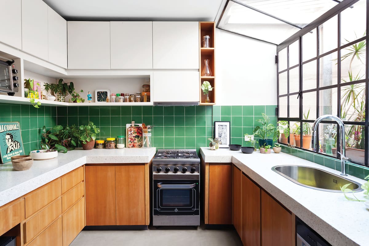 Foto de una cocina con muebles, bacha. Letrero vintage y figurita de la reina de Inglaterra comprados en viajes.