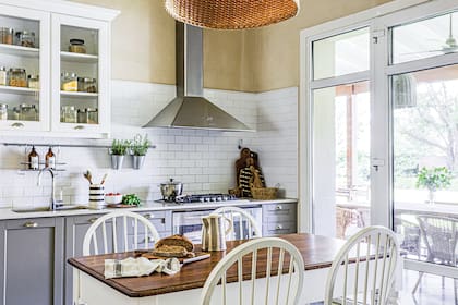 El mueble de la cocina tiene puertas replanadas (De Otro Tiempo). Mesada de Corian. Alzada con azulejos ‘Subway’.