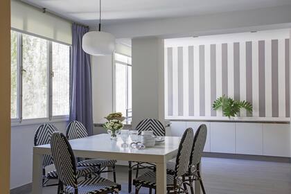 Piso cerámico símil madera (SBG). Lámpara (Iluminación Agüero). Mesa laqueada con sillas de ratán sintético (TW Buenos Aires). Empapelado a rayas grises y blancas (Raldua). Cortinas de pana (Caro Deane, confeccionadas por Gloria Furtado).