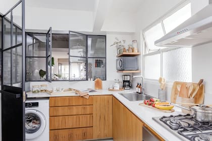 La carpintería de vidrio repartido y hierro negro en L fue diseñada por Josefina, que también proyectó el mueble de petiribí con mesada de Silestone ‘Blanco Norte’ (realizado junto a la arquitecta Camila Monge).