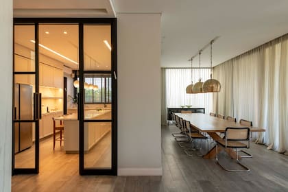 En paralelo a la gran barra, en el sector del comedor una mesa generosa de madera es sede de reuniones con amigos y familia.