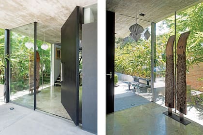 Sobria y sin molduras, la puerta de acceso parece un tabique más y se camufla con el revoque gris oscuro del exterior. Esculturas de madera en la entrada (30quarenta) y cuadros de escalera (Antonio Seguí y apaisados de Antonia Guzmán).