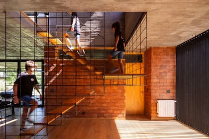 La escalera, en hierro y madera, no corta visualmente el espacio.