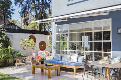 En la galería se cambiaron las sillas por un modelo metálico con tejido de cintas con protección UV (Salazar Casa). El camastro se mantuvo, renovaron los almohadones y les sumaron la mesa de lapacho.