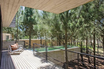 La pileta se ubicó de manera perpendicular para no interrumpir la vista. Es una estructura despegada del suelo y separada apenas unos centímetros de la galería. Sillones (Negro).