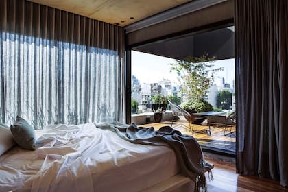 La suite tiene una cama laqueada con cajones diseñada por la dueña de casa, igual que el estante y las mesitas flotantes, con veladores (Ambos Lighting). Como complemento de las cortinas de lino de algodón (De Levie), un blackout con sistema roller (Decormundo) preserva el cuarto del sol.