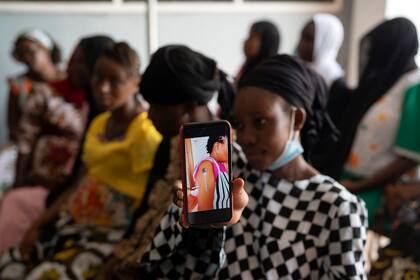 Foto del 23 de septiembre del 2021 tomada en un hospital de Serrekunda, Gambia, en la que Oumie Nyassi muestra un video que circula en las redes sociales con información sobre la vacuna contra el COVID-19 que se ha comprobado es falsa. En el video, una mujer dice haber quedado magnetizada después de recibir la vacuna. (AP Photo/Leo Correa, File)
